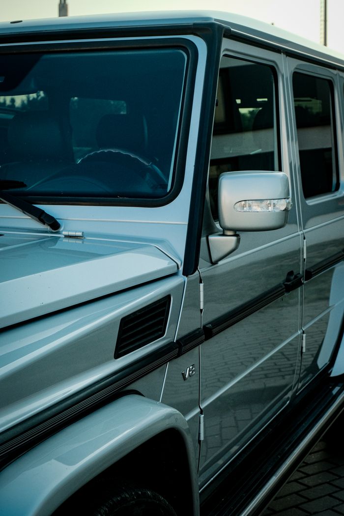 A detailed side view of a luxury SUV with chrome accents parked in an urban area.